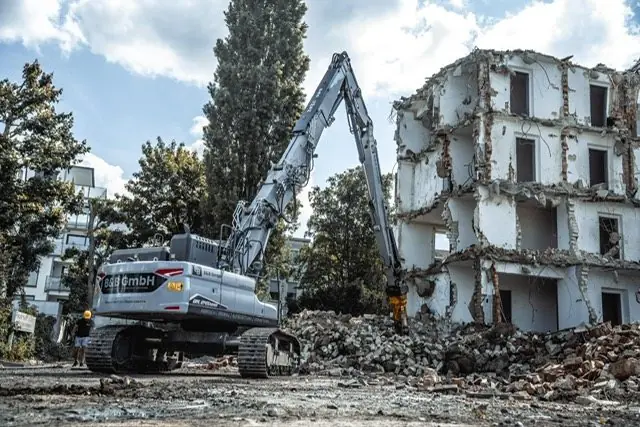 Abbruchbagger der B&B GmbH vor einem entkernten Gebäude