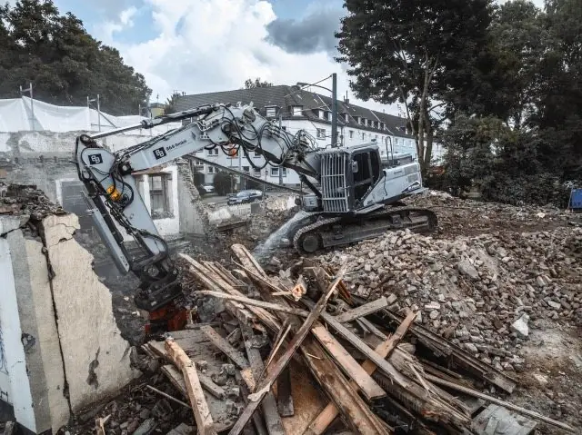 Abbruchbagger trennt Holz und Bauschutt
