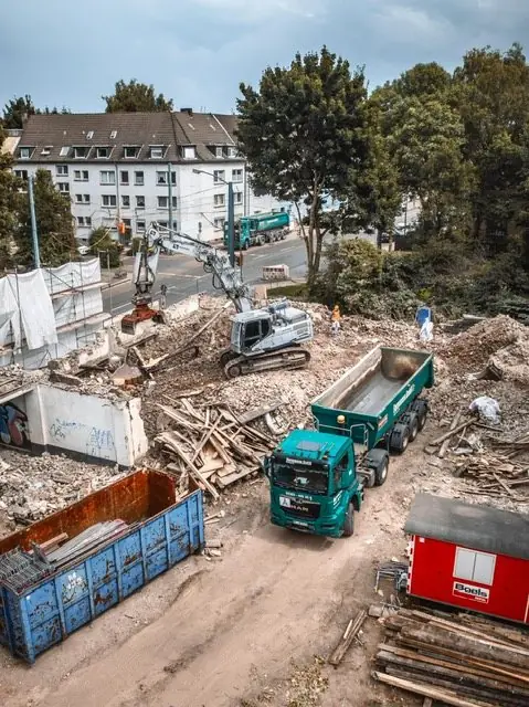 Abbruchbaustelle mit LKW und Containern, Luftbild