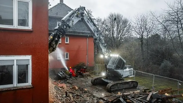 Hausabriss mit Wassernebel gegen Staub