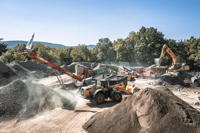 Mobile Aufbereitungskette der B&B GmbH in Dernau an der Ahr: Radlader Komatsu WA470 mit B&B-Logo, Kettenbagger, mobiler Prallbrecher und Haldenband bereiten Flutschutt zu RC-Baustoff auf
